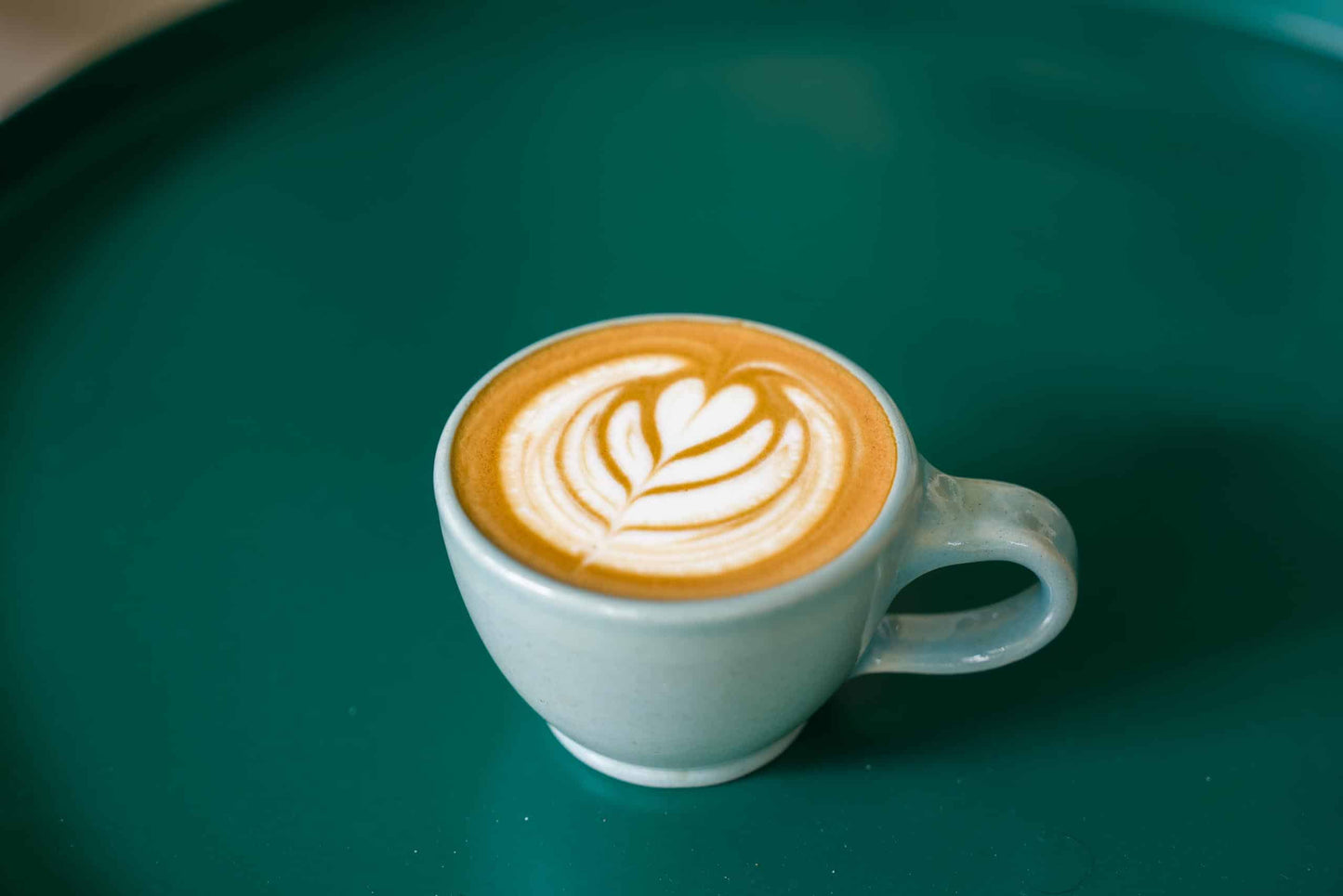 Handmade ceramic cappuccino coffee cup with coffee and latte art